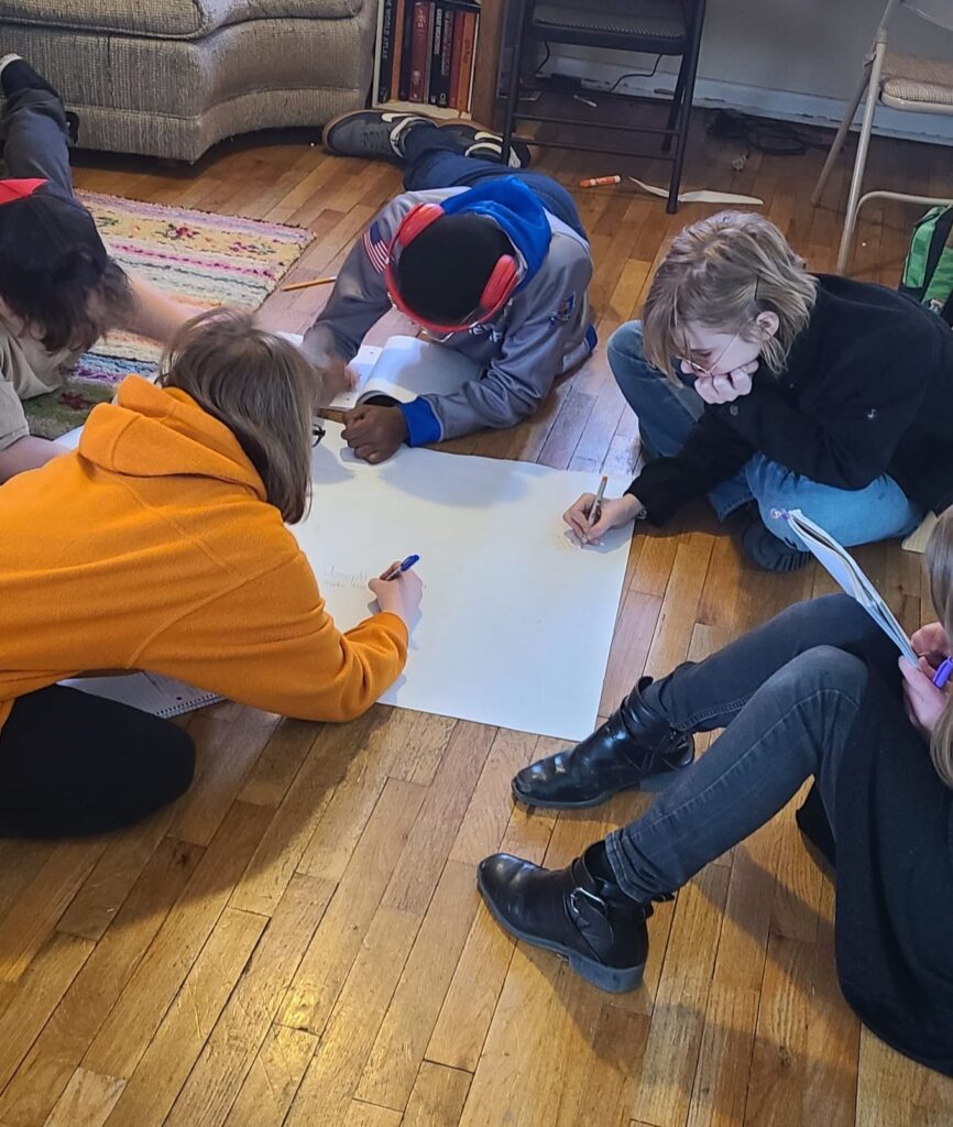 Students doing group learning on the floor at a Gatherpoint Microschool in Topeka, Kansas
